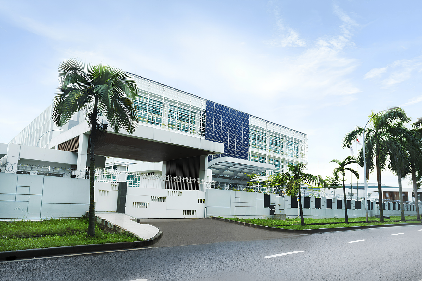 Exterior of the PT Nextier Askara Center data center facility in Jababeka, Cikarang, with palm trees and secured perimeter